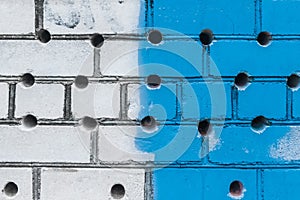 Abstract old design of dirty brick white wall with round holes pattern and blue paint texture background