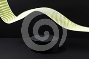 Abstract one black round podium with glowing neon yellow light line as motion trail for cosmetic products