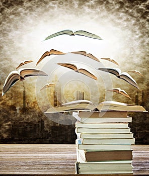 Abstract of open book on stack and flying book to the light over