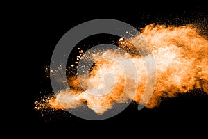 Abstract orange powder explosion on black background.
