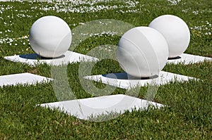 Abstract outdoor composition of white balls on bases