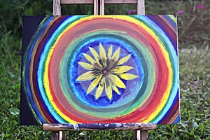 Abstract painting on canvas on easel in the summer park.