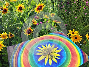 Abstract painting on canvas in the summer park. Yellow rudbeckia flower and rainbow circles.