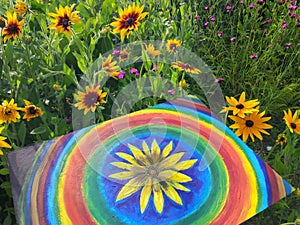 Abstract painting on canvas in the summer park. Yellow rudbeckia flower and rainbow circles.