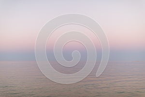 Abstract pastel pink ocean sunset. Peaceful water and sky