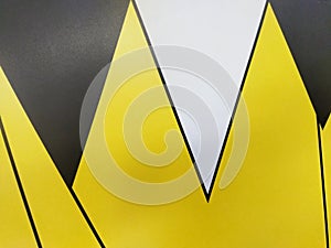 An abstract pattern features sharp, overlapping yellow and black triangles