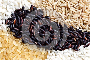 Abstract pattern made of black, white, brown and parboiled rice