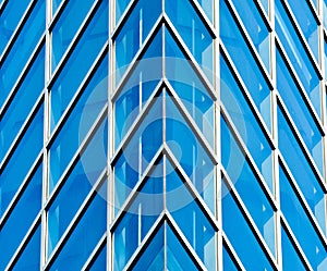 Abstract pattern of modern glass windows building with reflection from building skyscrapers of business center in the city.