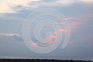 Abstract Pattern of Orange Red Colors created in Morning Sky with Clouds over Ocean - Natural Background