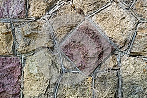 Abstract patterns of stones cemented into an exterior wall