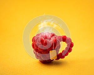Abstract photo of a cup of raspberry tea on a yellow background