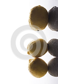 Abstract photo of lemons.Ripe lemans on the grey surface, shadows and bright light photo