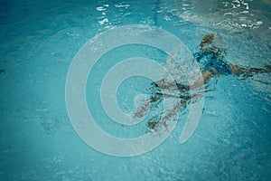 Abstract photo lifestyle, nature background. Unrecognizable person body deep under water, look at surface. Mystery mood