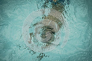 Abstract photo lifestyle, nature background. Unrecognizable person body deep under water, look at surface. Mystery mood