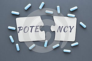 abstract photo of problems with potencies, two jigsaw puzzles with the words potency and pill capsules on a blue