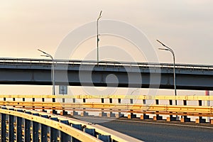 Abstract photo of traffic intersection. Metal construction of road bridge against blue sky. The New Darnytskyi Bridge
