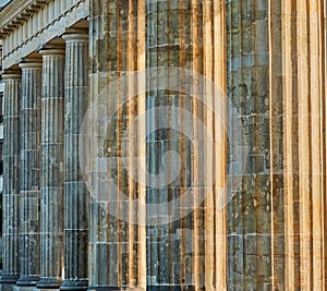 Abstract photograph of the columns of the Brandenburg Gate in Berlin in the back light of the morning sun, pattern background or