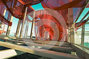 Abstract photographic picture with red sails. Red sails flutter in the wind on white frames on the seashore  copy space