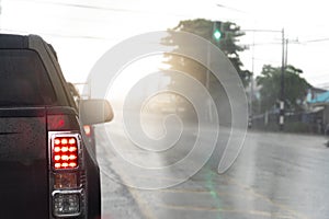Abstract of pick-up car with open tail light. Cars drive forward at green traffic lights.