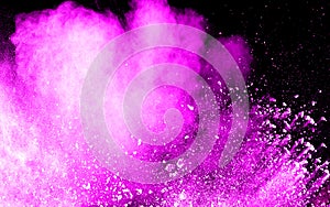 Abstract pink dust explosion on black background.