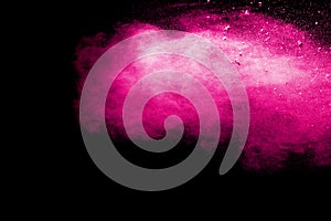 Abstract pink dust explosion on black background.abstract pink powder splattered on black background