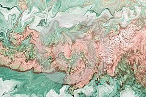 Abstract pink waves on green background with golden inclusions. Free flowing paint. Acrylic fluid art photo