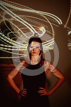 Abstract portrait of a beautiful girl in the light of the projector. Warm orange shades. Light bulb Edison. A feeling of