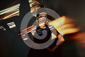 Abstract portrait of a beautiful girl in the light of the projector. Warm orange shades. Light bulb Edison. A feeling of