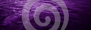 Abstract purple background. Reflection of light on a wavy water surface. Ripples. Beautiful magenta background with copy space fo