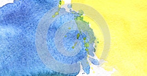 Abstract real watercolor background. A large yellow spot is iridescently flowing into a blue blot. Lots of small spatter.