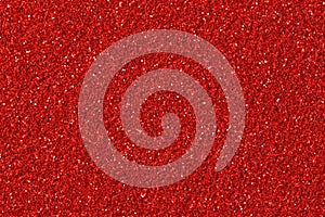 Abstract red Christmas glitter background. Red glitter texture close-up.