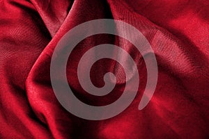Abstract red fabric background texture. Waves of satin velvet material