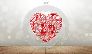 Abstract red heart floating over wooden floor texture with light blurred bokeh background.