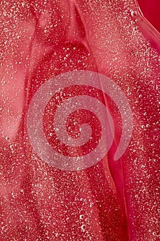 Abstract red liquid background, paint splash, swirl pattern and water drops, beauty gel and cosmetic texture