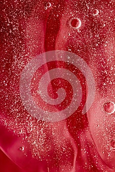 Abstract red liquid background, paint splash, swirl pattern and water drops, beauty gel and cosmetic texture