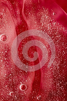 Abstract red liquid background, paint splash, swirl pattern and water drops, beauty gel and cosmetic texture