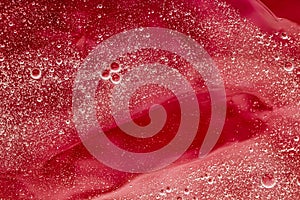 Abstract red liquid background, paint splash, swirl pattern and water drops, beauty gel and cosmetic texture