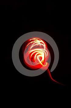Abstract red orange spiral motif light painting on black background