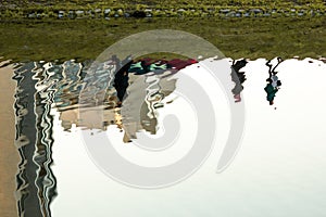 Abstract reflection in the water. Sunny day. Distorted view with ripples. Urban shot.