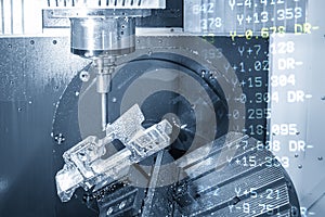 The abstract scene of 5 axis CNC milling machine cutting the aerospace part with the g-code data background.