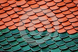 Abstract scene of red Brown and green  earthenware tiles or calls tiles consists of fish scales on the roof of temple bangkok thai