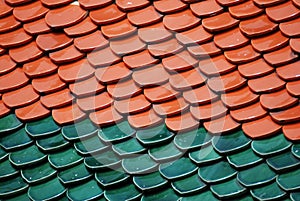 Abstract scene of red Brown and green  earthenware tiles or calls tiles consists of fish scales on the roof of temple bangkok thai