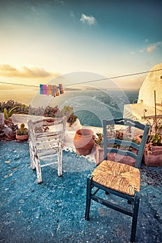 Abstract scene of two wooden chairs on a patio on Santorini.