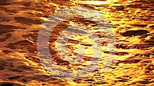 Abstract sea ocean orange warm sunset nature background. Small waves on golden water surface in motion blur with golden