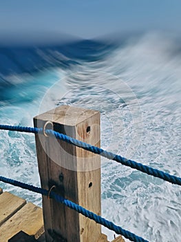 Abstract sea with pier and railing.