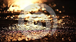 Abstract sea summer ocean sunset nature background. Small waves on golden water surface in motion blur with golden bokeh