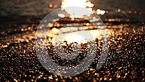 Abstract sea summer ocean sunset nature background. Small waves on golden water surface in motion blur with golden bokeh