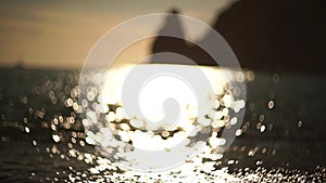 Abstract sea summer ocean sunset nature background. Small waves on golden water surface in motion blur with golden bokeh