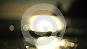 Abstract sea summer ocean sunset nature background. Small waves on golden water surface in motion blur with golden bokeh