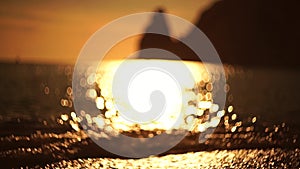 Abstract sea summer ocean sunset nature background. Small waves on golden water surface in motion blur with golden bokeh